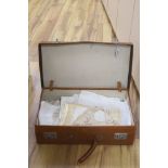 A brown leather suitcase of table linens