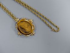 A yellow metal mounted tiger's eye quartz oval pendant, 48mm, carved with the bust of a lady to