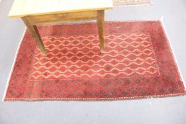 A Belouch red ground rug, 200 x 115cm