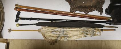 A Chinese bamboo walking stick, two parasols and another stick