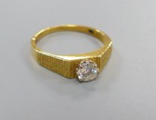 A modern 18ct gold and solitaire diamond ring, with textured shoulders, size N, gross 2.9 grams, the