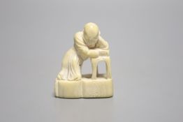 A Japanese ivory netsuke of a sleeping scholar at his table, 18th/19th century, height 4.5cm