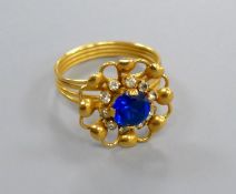 A Middle Eastern yellow metal ring, set with a blue and white paste stones, size O/P, gross 4.8