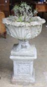 A reconstituted stone garden planter on plinth base, 49cm diameter, height 84cm
