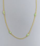 A modern 9ct gold and eight stone cabochon jade set 'spectacle' necklace, 60cm, gross 9.1 grams.