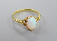 A yellow metal and cabochon oval white opal set dress ring, size O, gross 2.7 grams.CONDITION: A few
