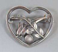 A Georg Jensen sterling heart shaped brooch, depicting twin leaping dolphins with frond, no. 312,