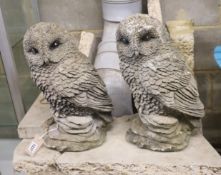 A pair of reconstituted stone garden ornaments modelled as owls, height 41cm