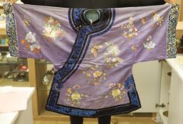 A Chinese lilac silk embroidered robe, early 20th century with multi-coloured embroidery and wide