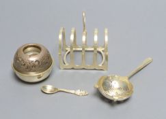 A silver tea strainer, Sheffield, 1964, a George V silver toast rack and an early 20th century