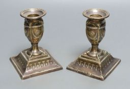 A pair of Victorian silver dwarf candlesticks of Neo-Classical design, with swags, paterae and ram's