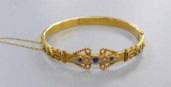 An Edwardian 9ct, sapphire and rose cut diamond chip set hinged bangle, gross 7.7 grams.CONDITION: