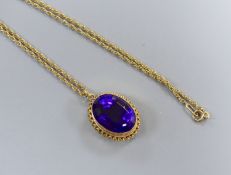 A modern 9ct gold and oval cut amethyst set pendant, 24mm, on a 9ct chain, 46cm, gross 10.8 grams.