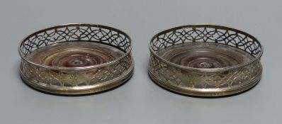 A pair of George III silver bottle coasters having pierced sides and thread edge borders, each