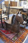 A large decorative carved hardwood horse shaped stool, 60cm. long. 26cm. wide. 72cm. high.
