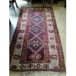 A Causcasian polychrome geometric ground rug, 260 x 130cm