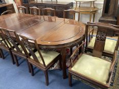 A 20th century Chinese carved hardwood dining room suite comprising sideboard fitted with four