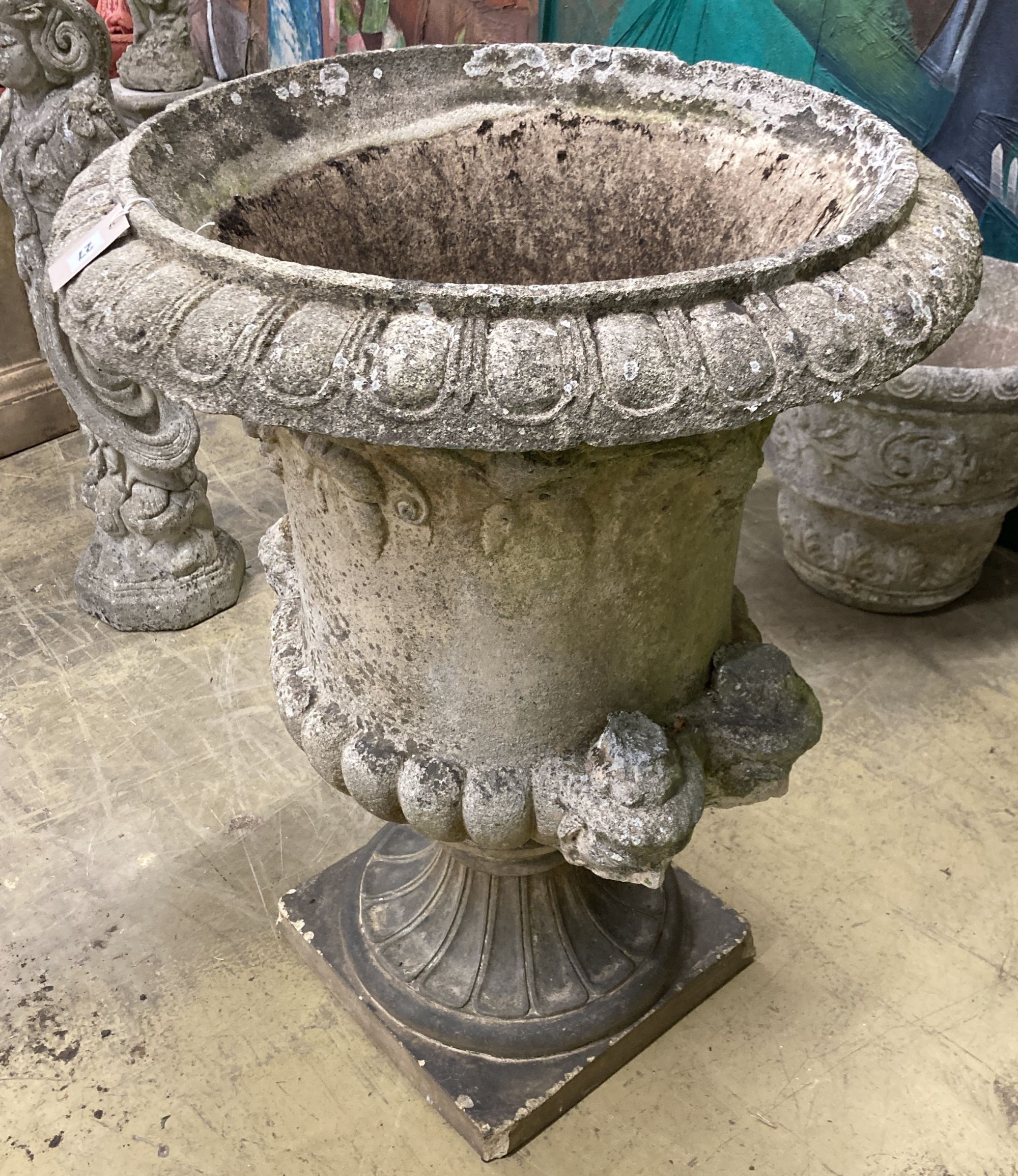 A large reconstituted stone campana garden urn, handles in need of repair, 75cm diameter, height