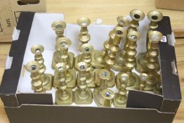 A large canteen of various brass candlesticks, mostly 19th century