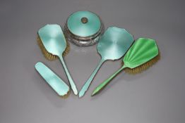 A 1930's silver and enamel toilet set including powder bowl, mirror and two brushes and one other
