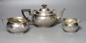 An Edwardian demi-fluted silver three piece tea set, Mappin & Webb, Sheffield, 1902,gross 31oz.