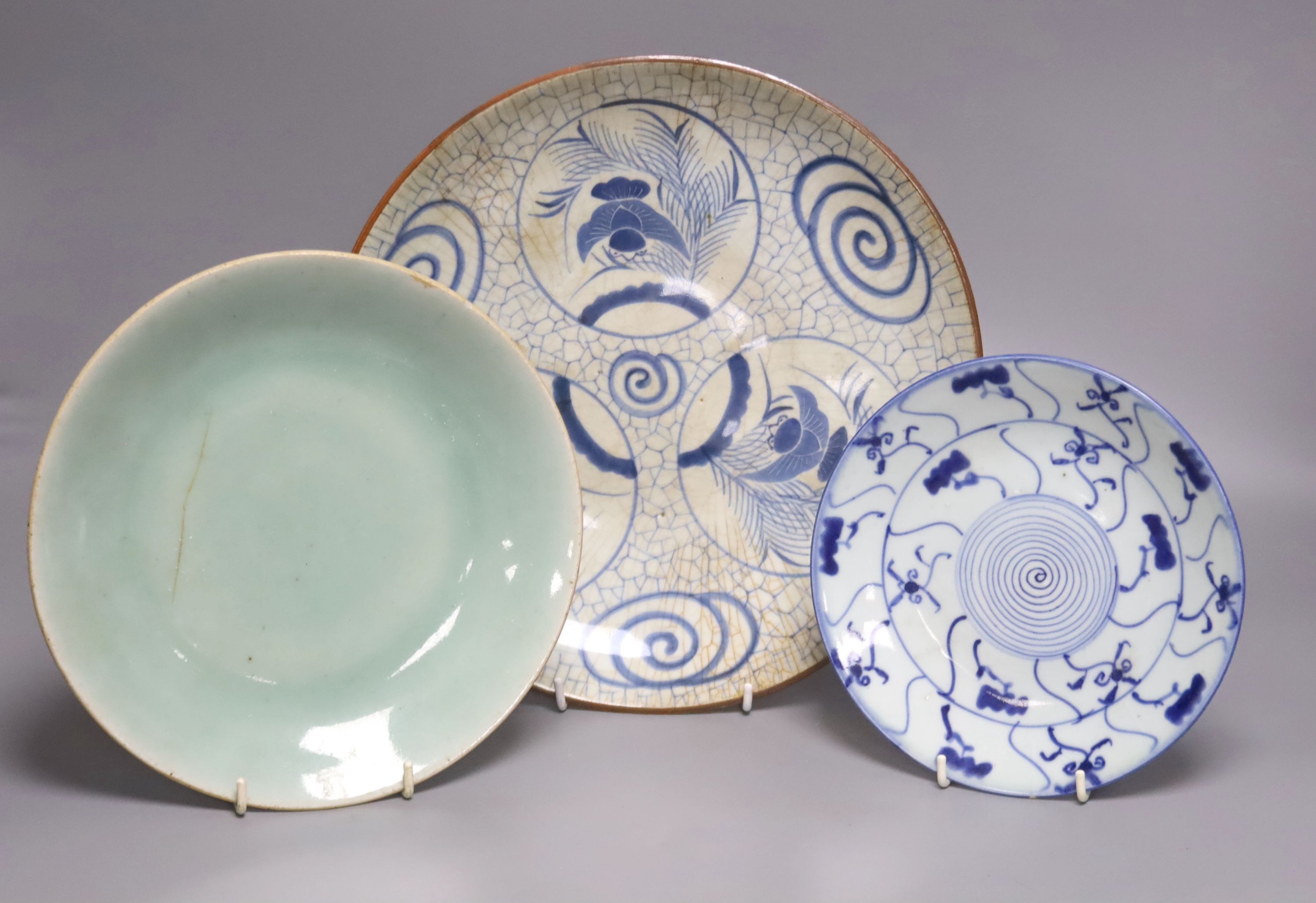 A Japanese crackle glazed dish, another similar and a Chinese celadon glazed dish, largest