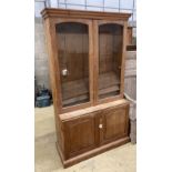 A glazed pine bookcase / cupboard, width 106cm, depth 46cm, height 196cm