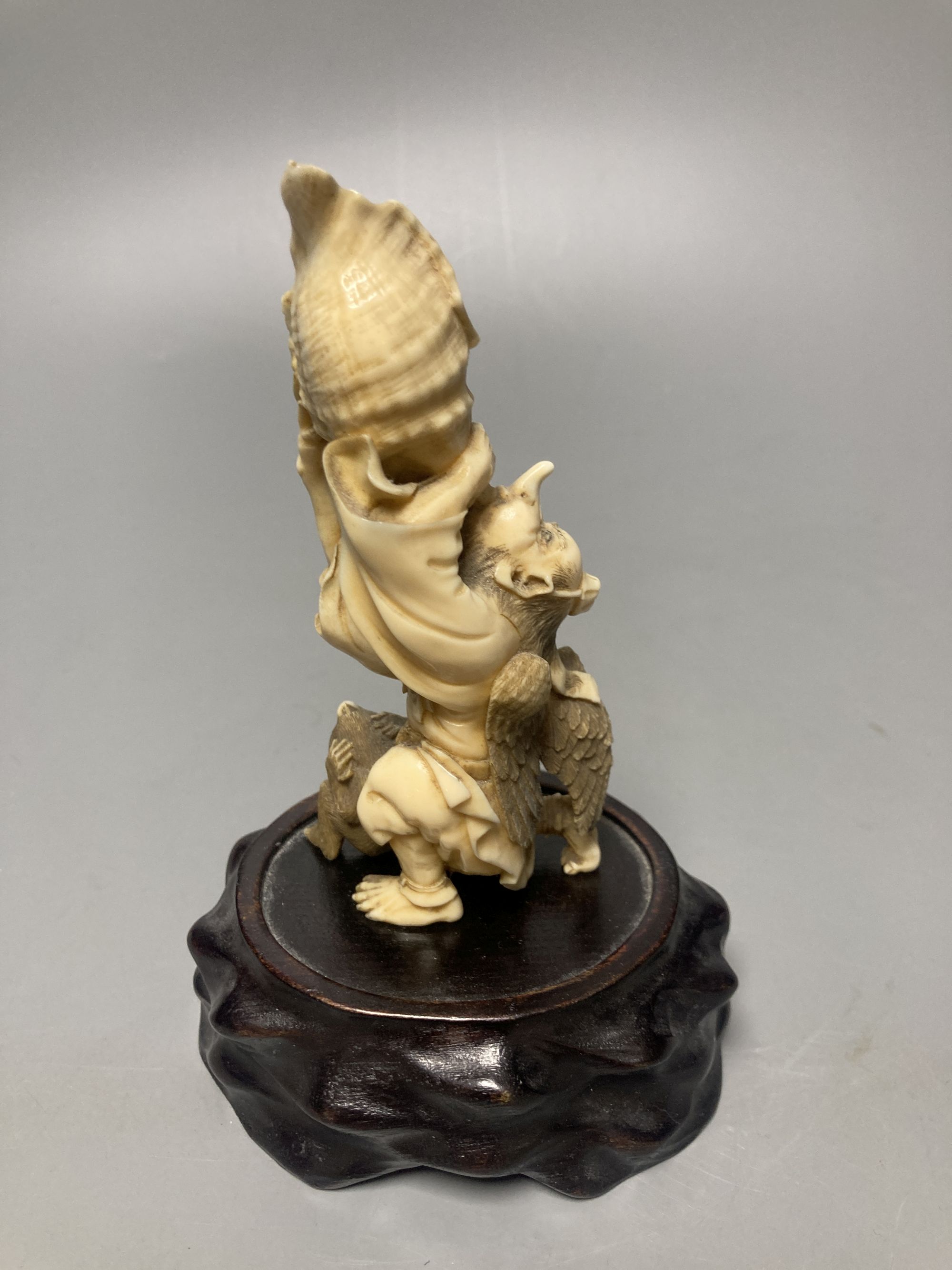 A Japanese ivory okimono of a winged man blowing a conch, monkey below, Meiji - Image 3 of 4