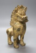 A South East Asian gilt metal lion-dog, height 27cm