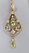 An early 20th century 9ct, peridot and seed pearl set drop pendant, 54mm, on a fine link yellow