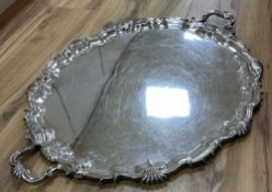 A large plated twin-handled shaped oval tray with shell and scroll border, L 76cm overall