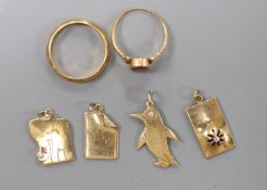 Four modern 9ct gold charms, a continental yellow metal wedding band and one other ring,9ct gross