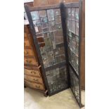 An early 20th century glazed oak two fold screen, each panel width 51cm, height 176cm