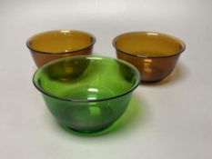 A pair of Chinese Beijing amber glass bowls, together with a similar green glass bowl, diameter