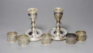 A pair of modern silver dwarf candlesticks, 12cm, a silver napkin ring and four sterling napkin