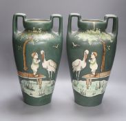 Two green vases with stork and child, enamelled decoration, height 37cm