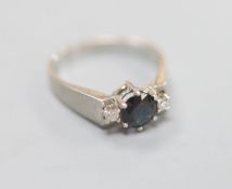 A modern 18ct white gold, sapphire and diamond set three stone ring, size M/N, gross 4.2 grams.