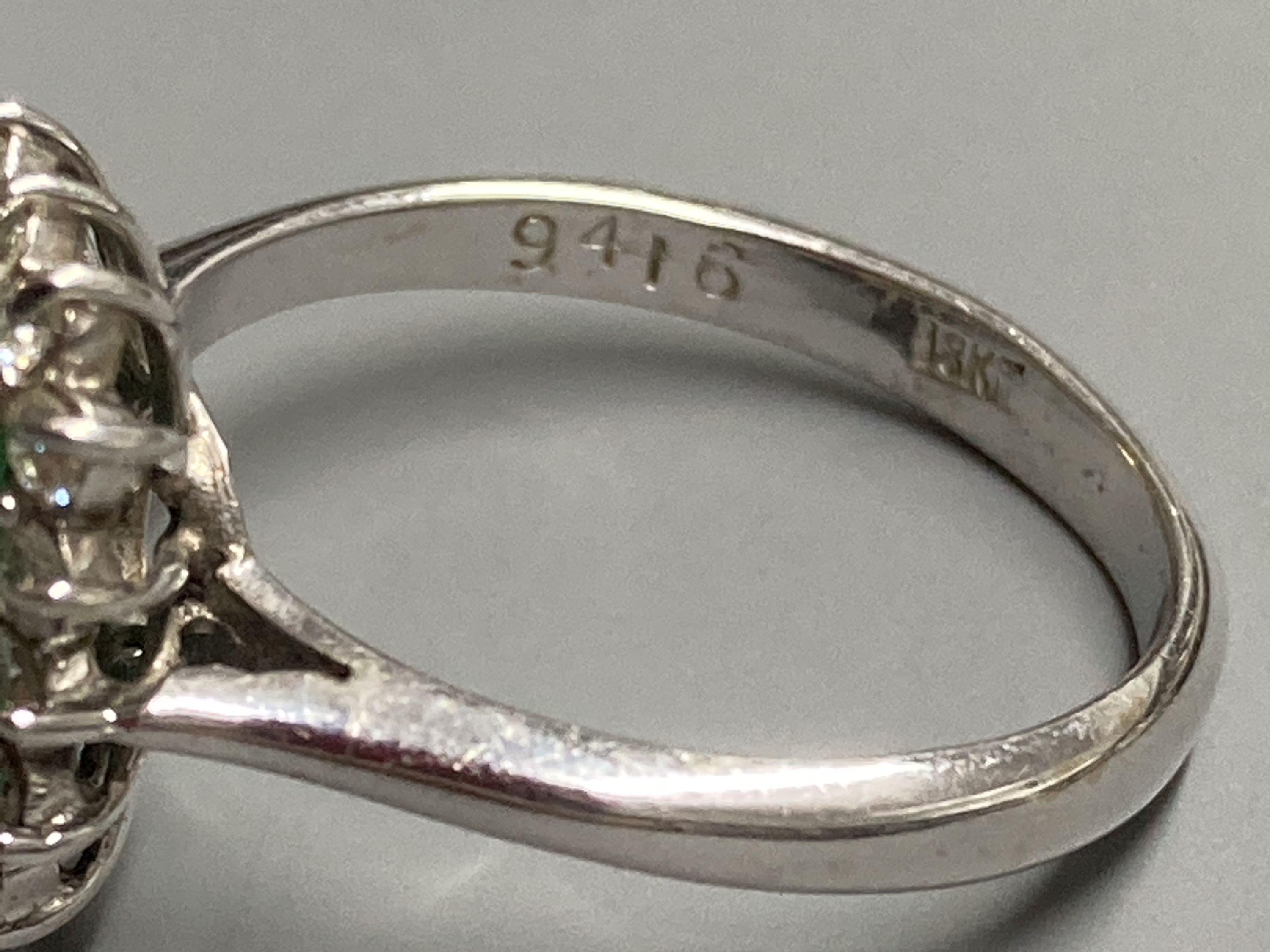 A modern 18ct white gold, emerald and diamond set rectangular cluster ring, size K, gross 3.4