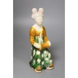 A large Chinese pottery figure of an aristocratic lady, wearing a floral skirt and seated, Tang