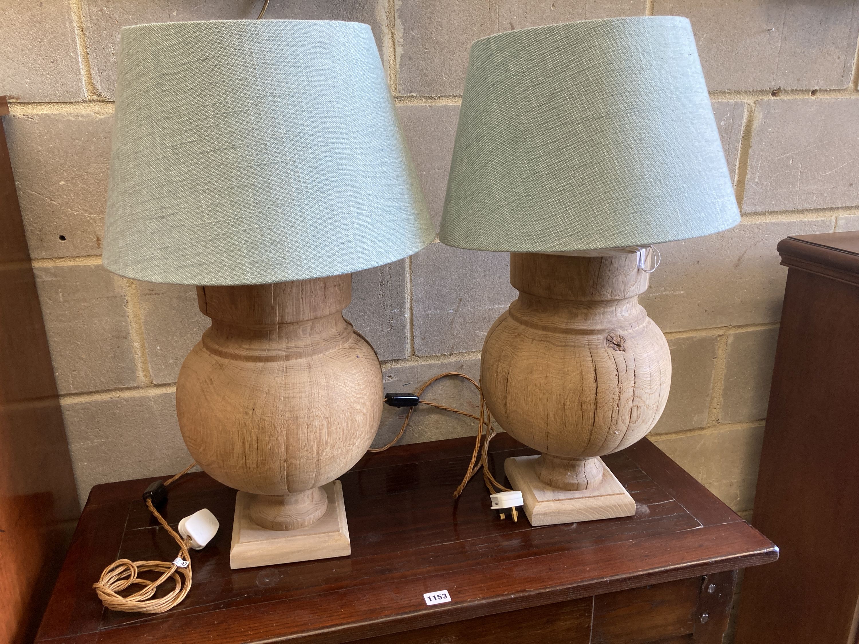 A pair of contemporary turned oak table lamps with shades, height 70cm