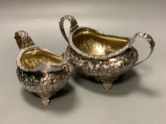A George the fourth embossed silver cream jug and to handle sugar bowl by Hyam Hyams, London 1824,