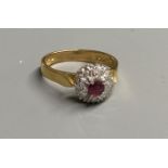 A modern 18ct gold, ruby and diamond chip set cluster ring, size M, gross 4.4 grams.