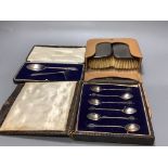 A cased pair of silver mounted clothes brushes, a cased silver spoon and pusher and a cased set a