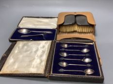 A cased pair of silver mounted clothes brushes, a cased silver spoon and pusher and a cased set a