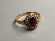 An early 20th century 9ct gold, garnet and seed pearl cluster ring, size O, gross 2 grams.
