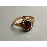 An early 20th century 9ct gold, garnet and seed pearl cluster ring, size O, gross 2 grams.