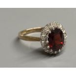 A modern 9ct gold, garnet and diamond set oval cluster ring, size N, gross 3.4 grams.