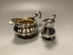 A George III silver baluster cream jug and a George IV silver cream jugof circular fluted form (2),