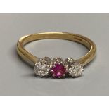 An 18ct, synthetic? ruby and diamond set three stone ring, size S, gross 3.6 grams.