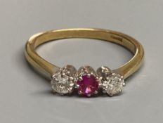 An 18ct, synthetic? ruby and diamond set three stone ring, size S, gross 3.6 grams.